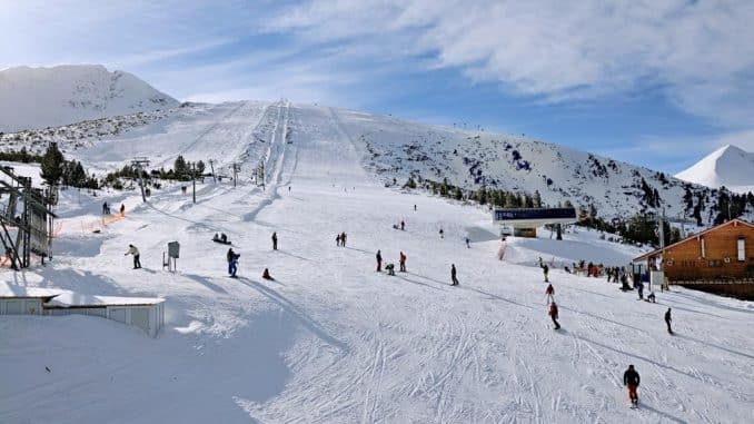 Ski zone Bansko, Bulgaria in sunny day skiers at resort
